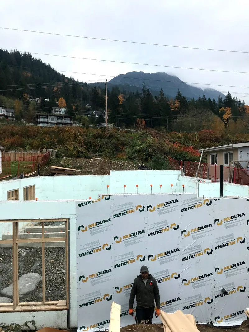 A foundation wall coated in fresh damp-proofing membrane.