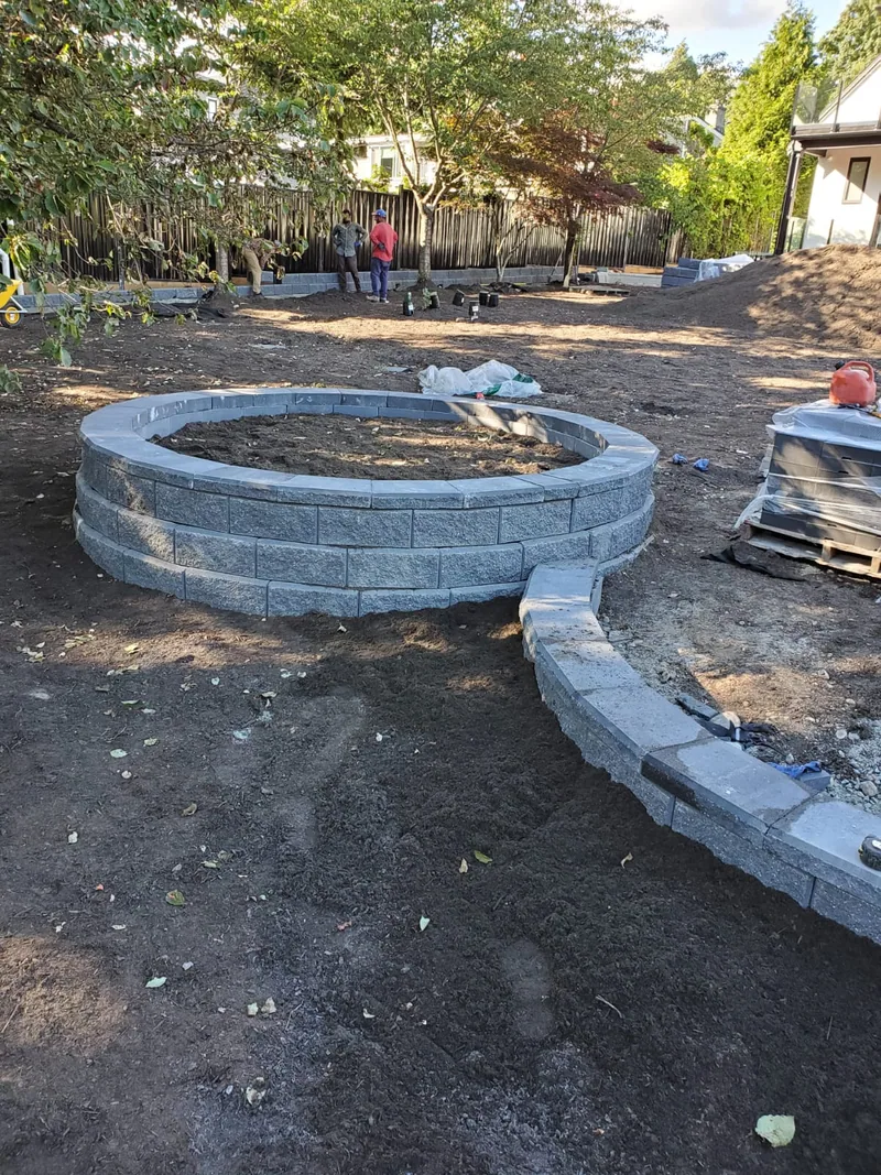 A custom-built garden waterfall and stone planter set into a landscaped backyard.