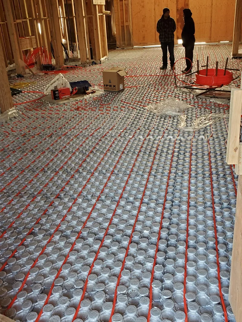 Rigid styrofoam insulation panels installed against a foundation wall before backfill.
